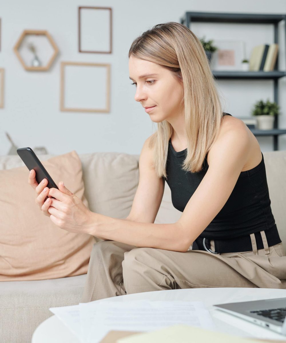 blond pretty girl in casualwear with smartphone sc K3J2CSV scaled